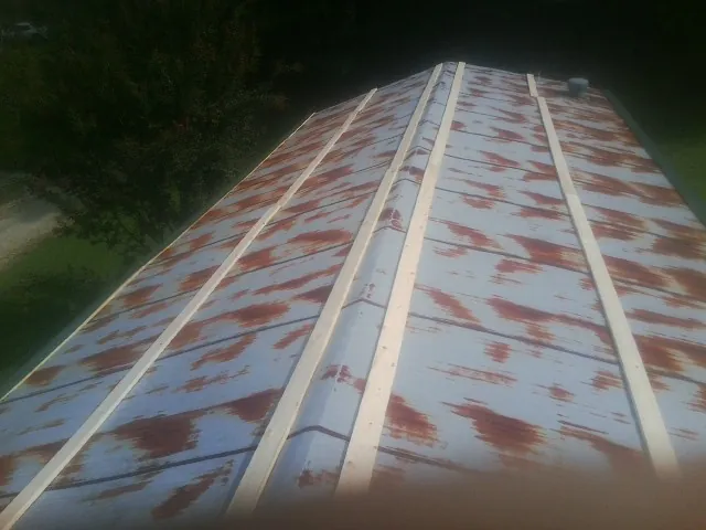 Rusted metal roof panels with new wood purlins before replacement — Storm Damage Roof Repair in Everson by Roofing Brothers